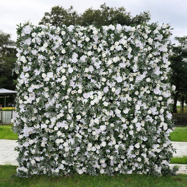 Elegant white floral wall backdrop with lush greenery for outdoor events.
