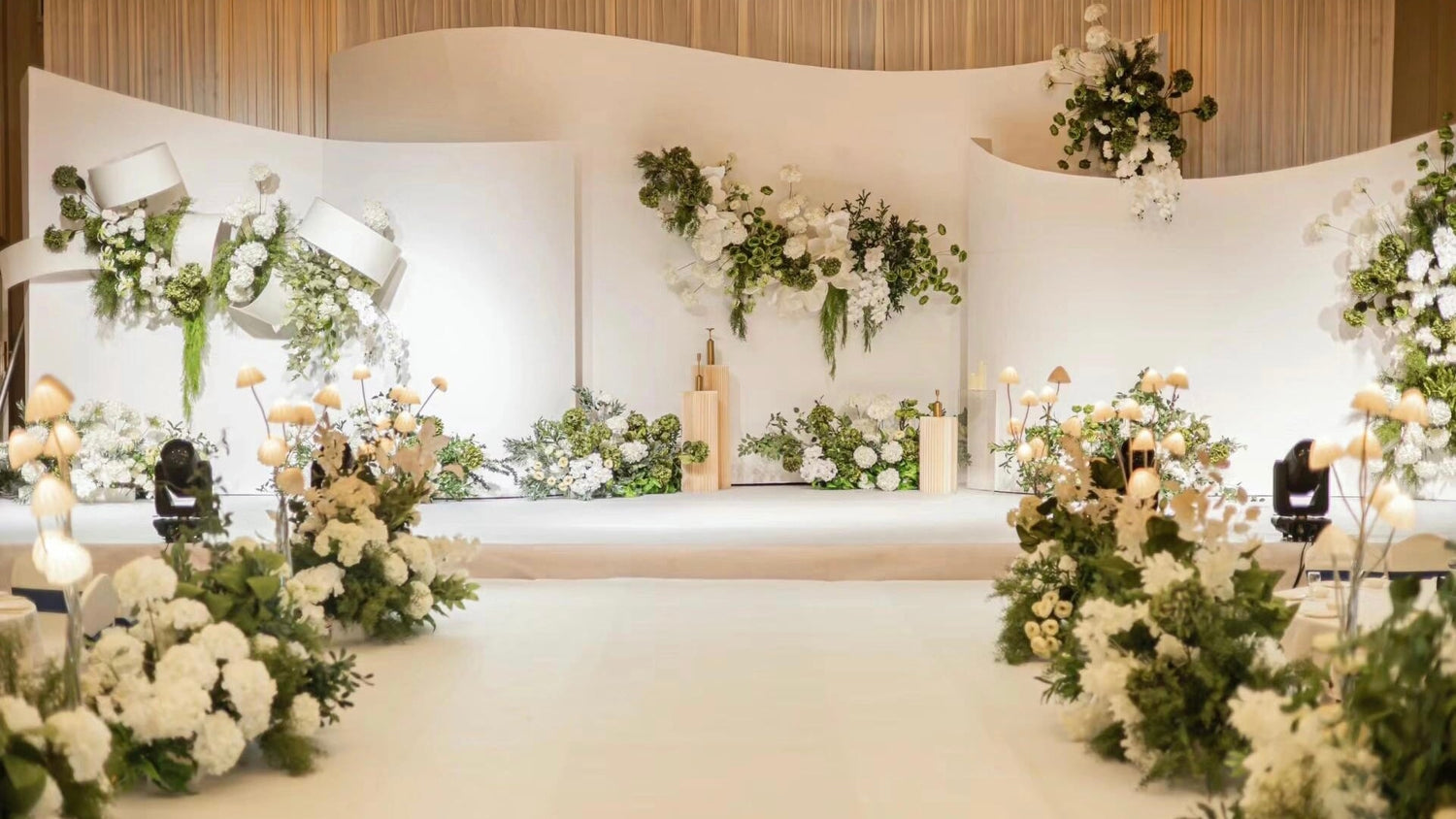 Elegant wedding aisle with floral arrangements and candle holders, leading to a beautifully designed backdrop with personalized text, perfect for a luxurious celebration.
